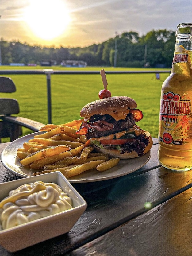 Burger mit Pommes und Bier auf der Terrasse